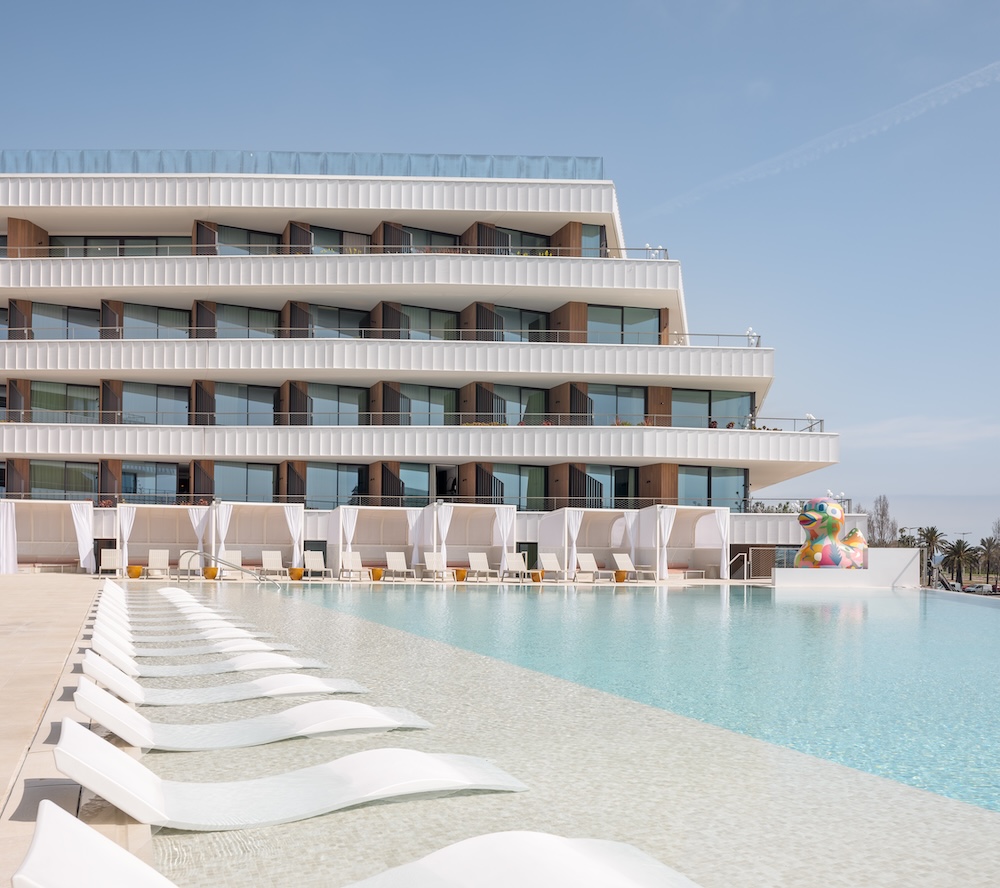 Pool with white sun loungers and cabanas with multi coloured duck