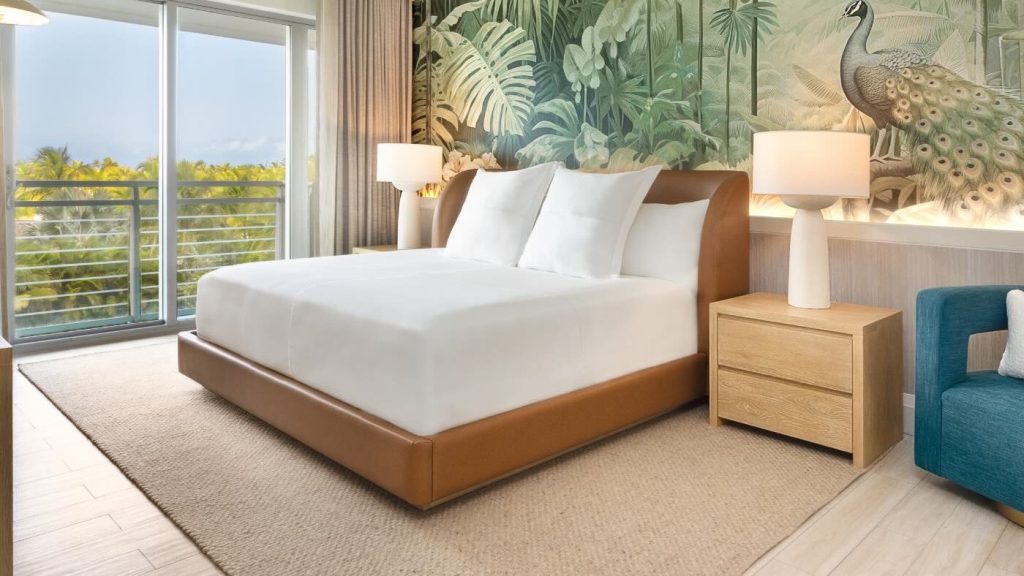 una cama de matrimonio con somier de cuero y papel pintado tropical detrás