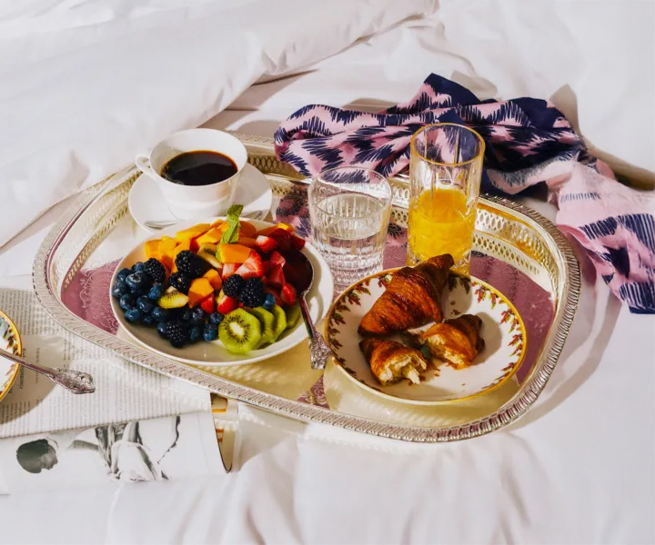 Breakfast in bed with delicious spread of food and beverages