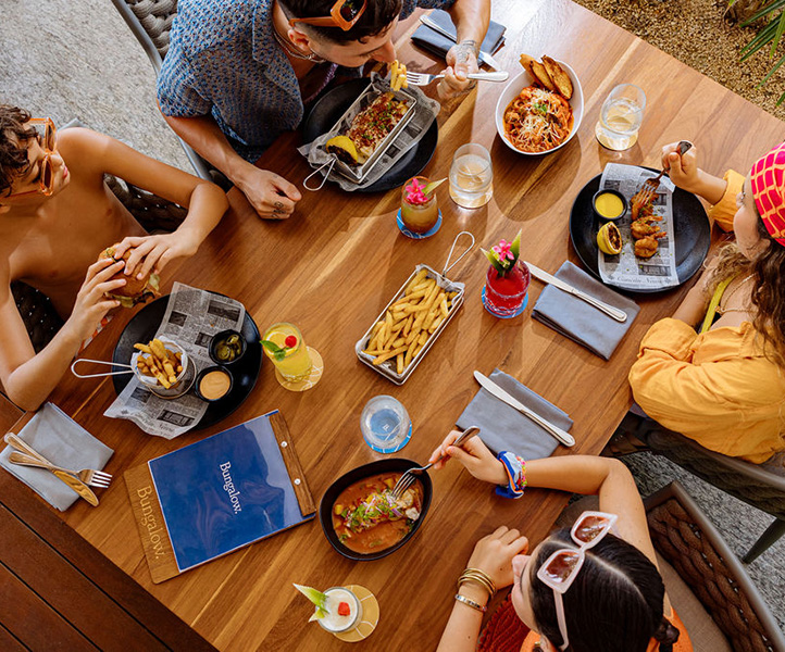 An overhead shot of a family of four eating lunch in a beach restaurant