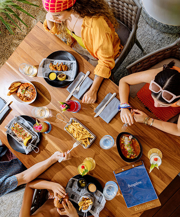 An overhead shot of a family of four eating lunch in a beach restaurant