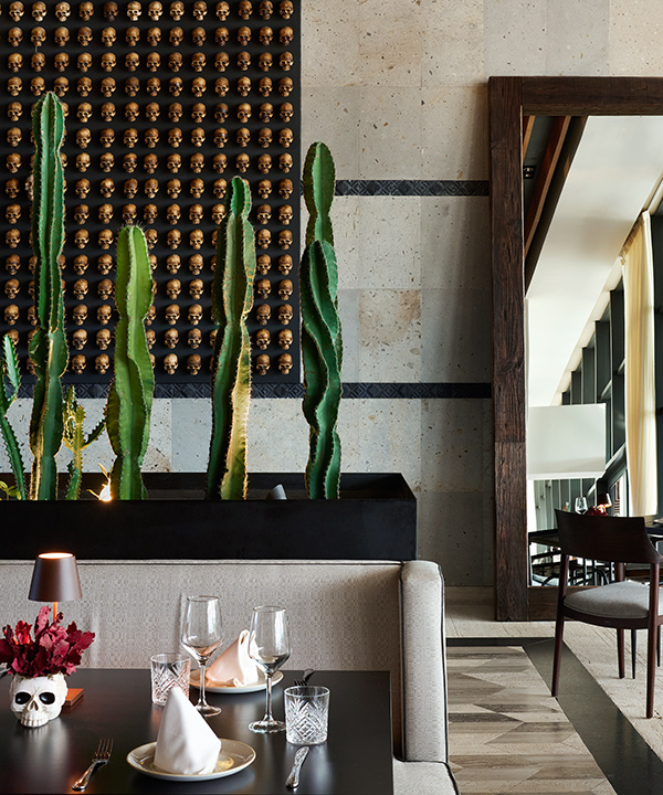 Interior of Caracol restaurant at SLS Playa Mujeres, featuring a big cactus
