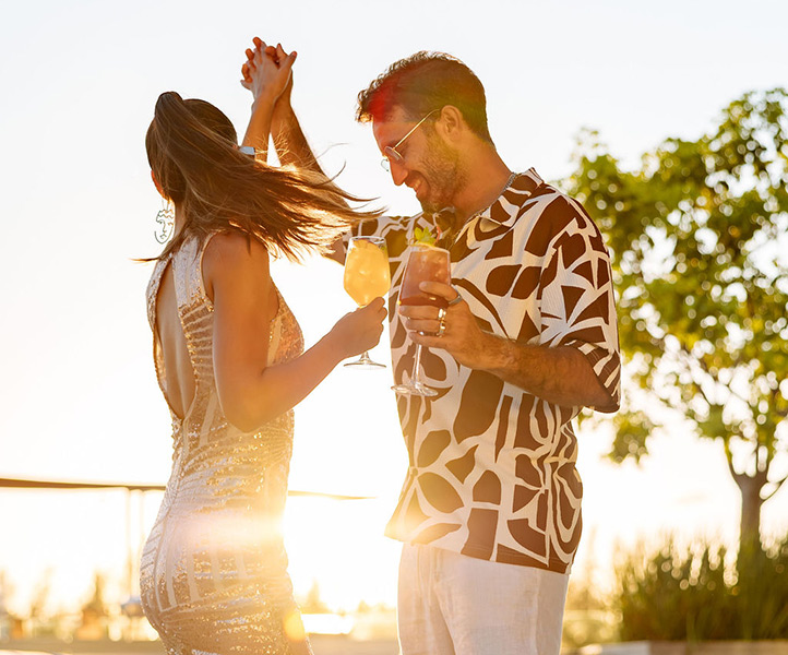 Couple dancing outside holding cocktails