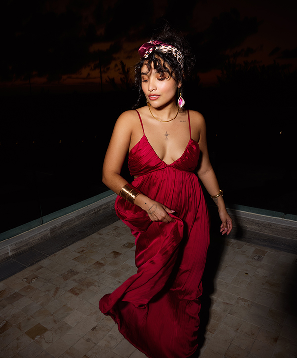 A girl in a red silk dress and a heard scarf dancing
