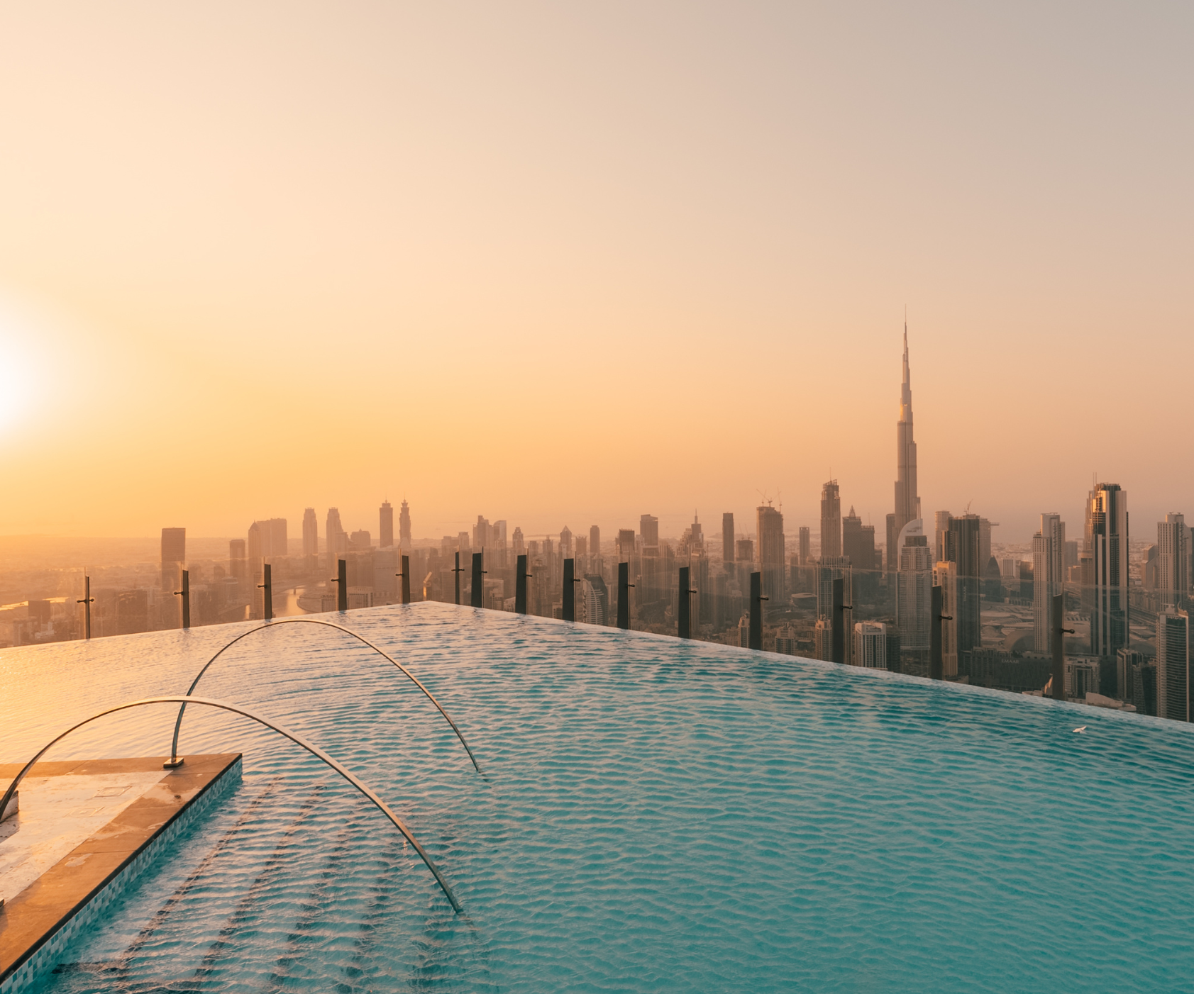 The dazzling rooftop infinity pool at sunset, with fantastical orange skies