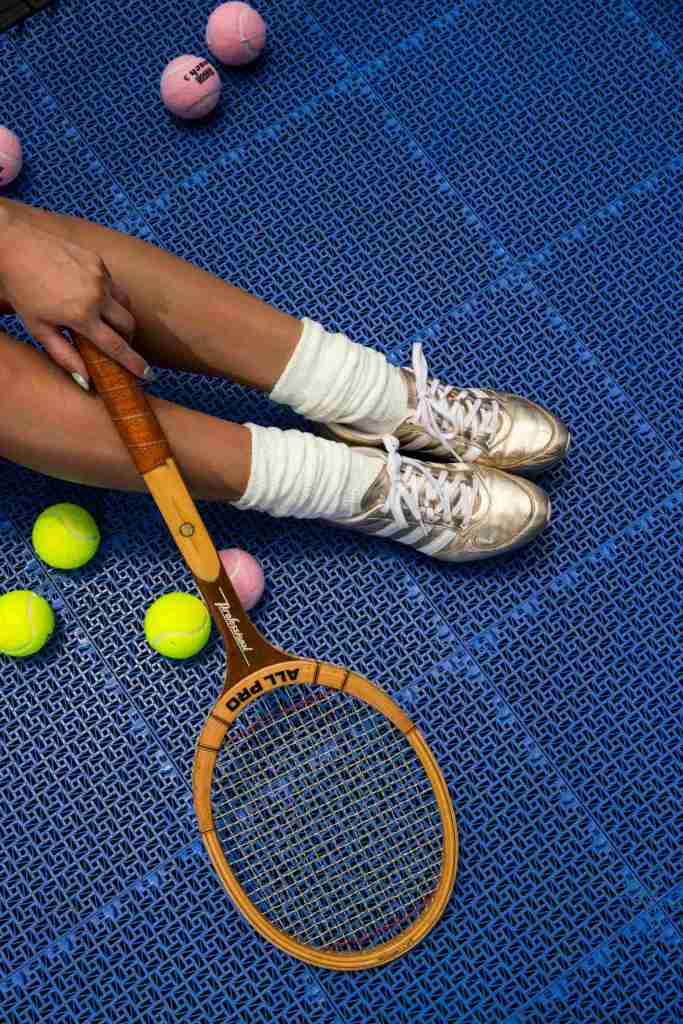 shot of tennis racket, balls and legs at the tennis court 